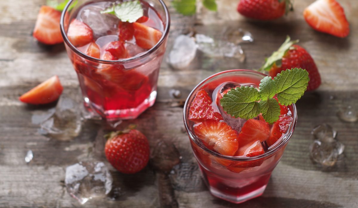 Summer drink with strawberry in glasses on the vintage wooden table, selective focus