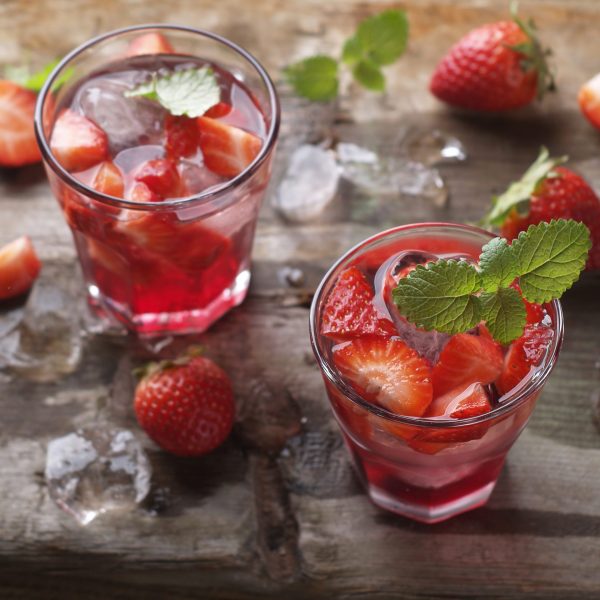 Summer drink with strawberry in glasses on the vintage wooden table, selective focus